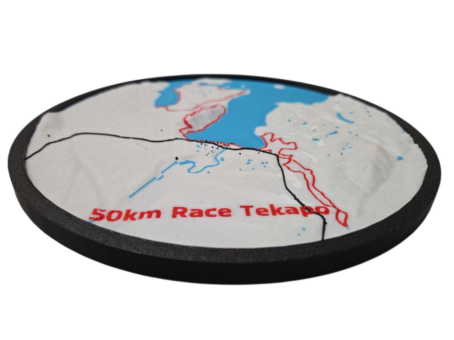 Round disc with a map design and '50km Race Tekapo' text on a white background